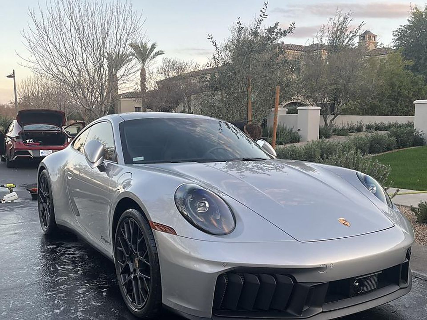 Freshly detailed silver Porsche 911 gleaming in a driveway